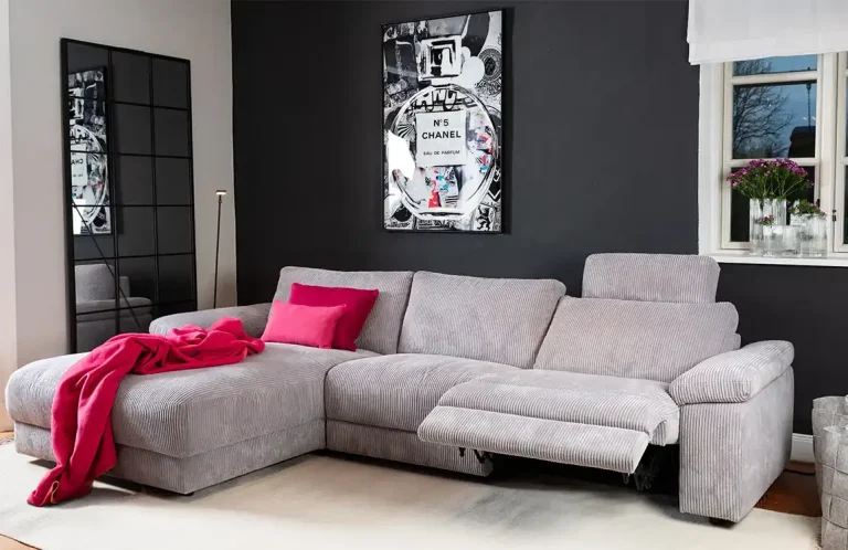 Beige Sofa mit Kissen und Decke, Holztisch in gemütlichem Wohnraum.